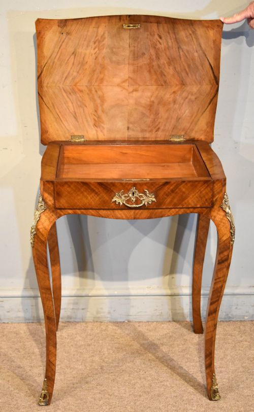 A 19th-century French walnut work table featuring curved cabriole legs, brass knee and foot mounts, a single front drawer with an ornate handle, and matched wood veneer. View III