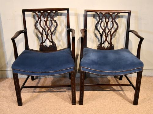 fig 1. A matched pair of dark mahogany Chippendale style armchairs with intricate pierced back splats and blue velvet upholstered seats with brass stud detailing.
