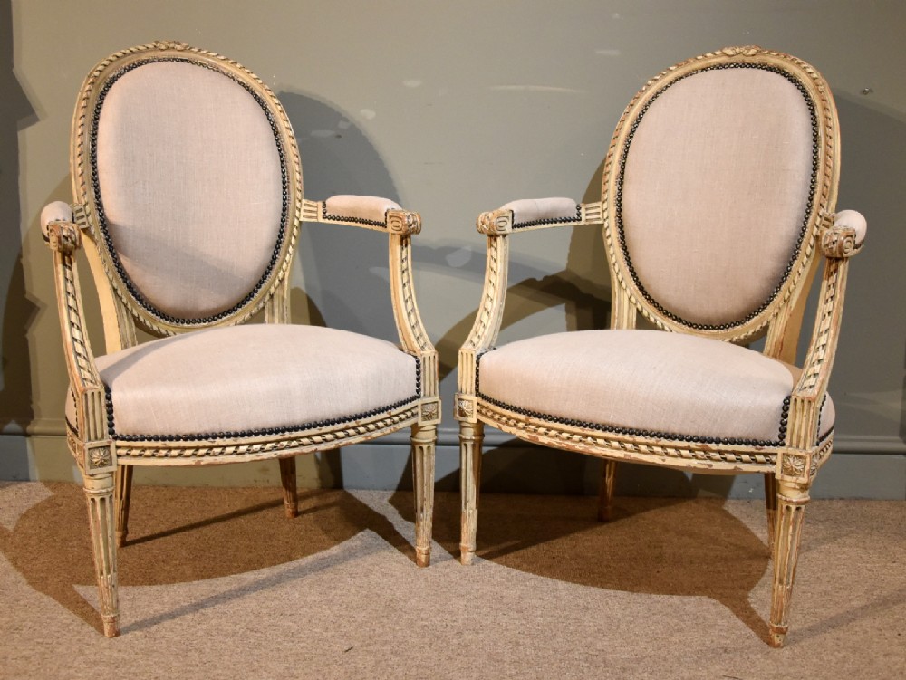 An Elegant Pair of Painted French Open Armchairs