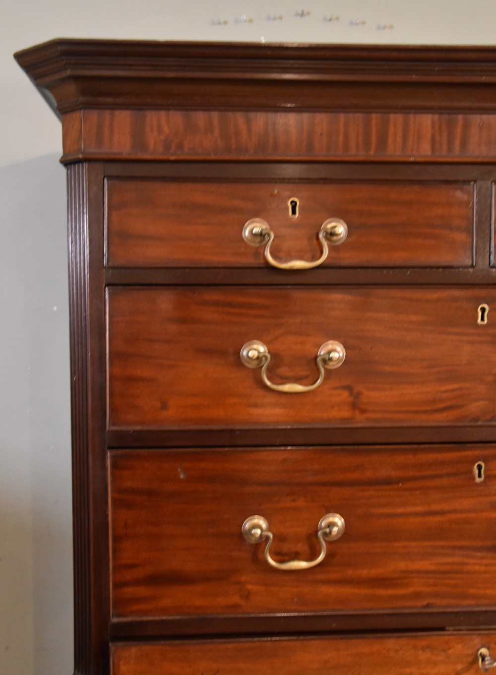 A George III mahogany chest on chest with an open secretaire drawer displaying small internal drawers, pigeonholes, and a green writing surface. View III