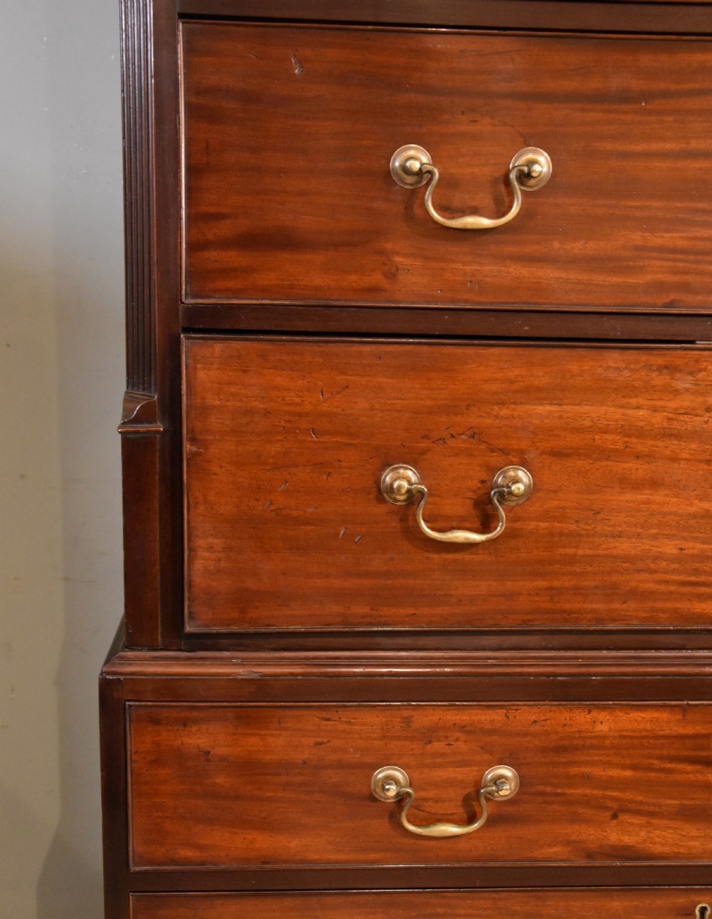 A George III mahogany chest on chest with an open secretaire drawer displaying small internal drawers, pigeonholes, and a green writing surface. View IV