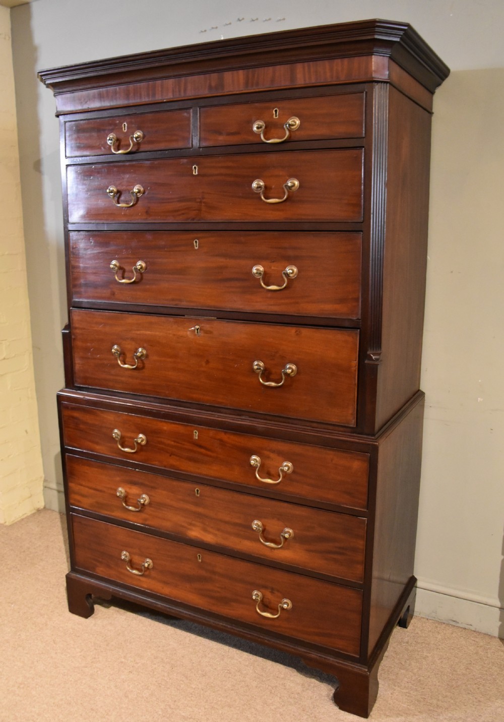 A George III mahogany chest on chest with an open secretaire drawer displaying small internal drawers, pigeonholes, and a green writing surface. View V