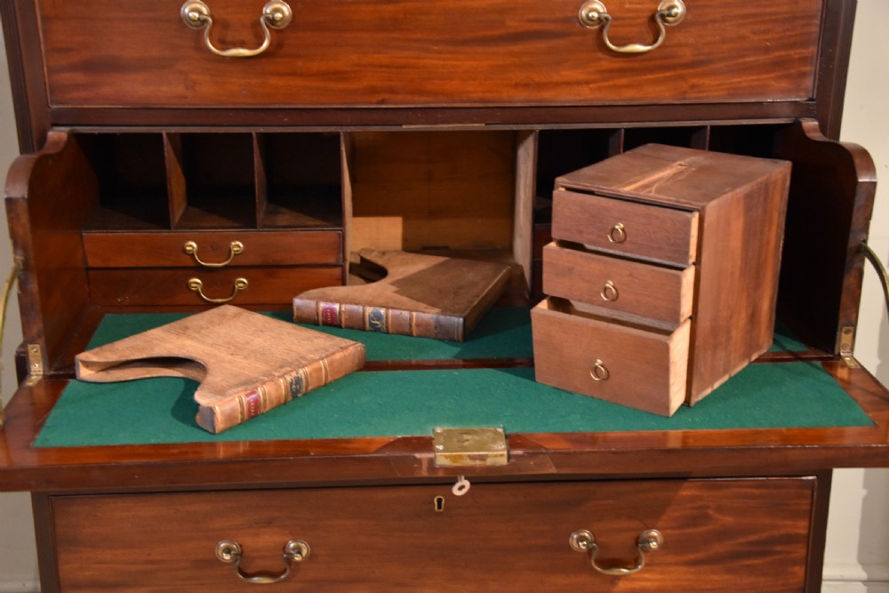 A George III mahogany chest on chest with an open secretaire drawer displaying small internal drawers, pigeonholes, and a green writing surface. View VI