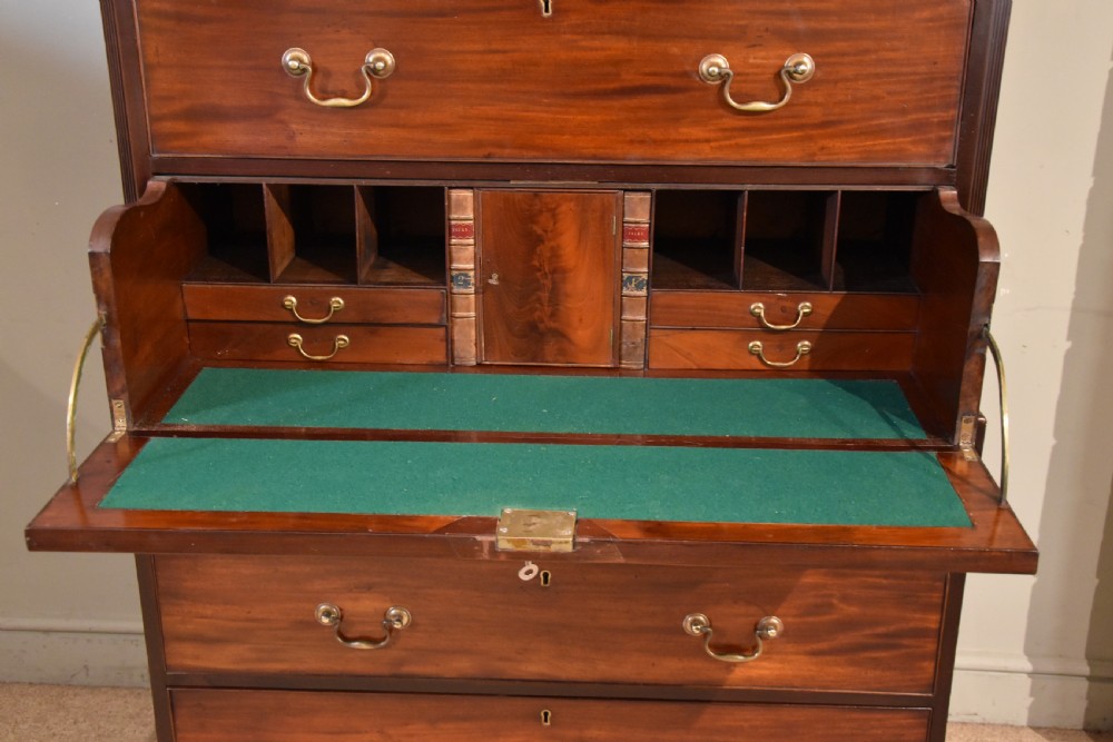 A George III mahogany chest on chest with an open secretaire drawer displaying small internal drawers, pigeonholes, and a green writing surface. View VII