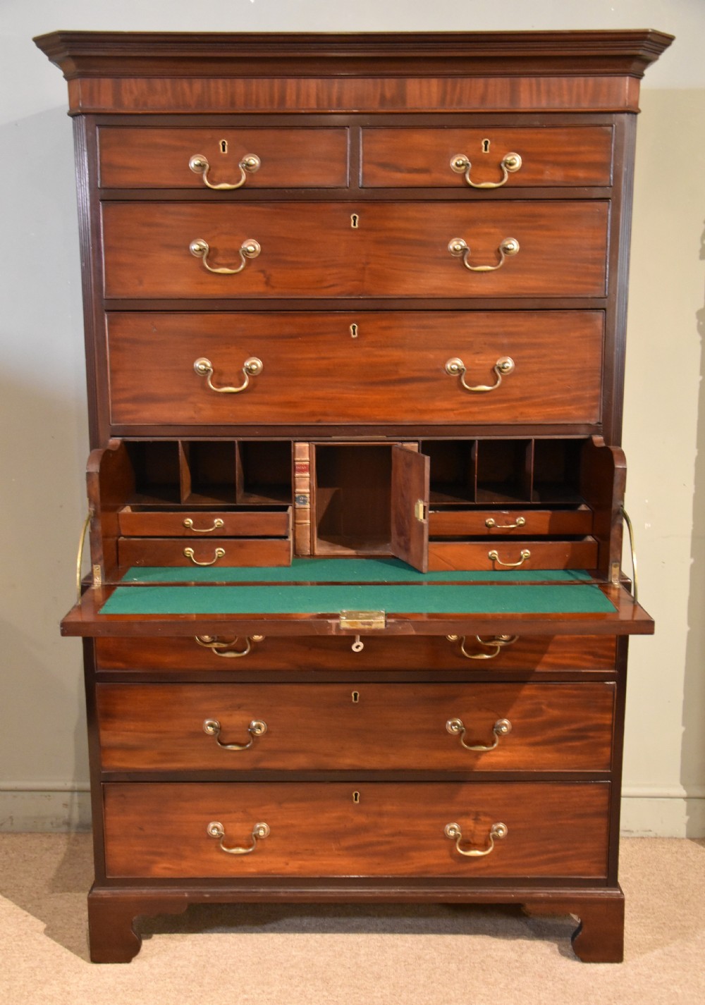A George III mahogany chest on chest with an open secretaire drawer displaying small internal drawers, pigeonholes, and a green writing surface. View VIII