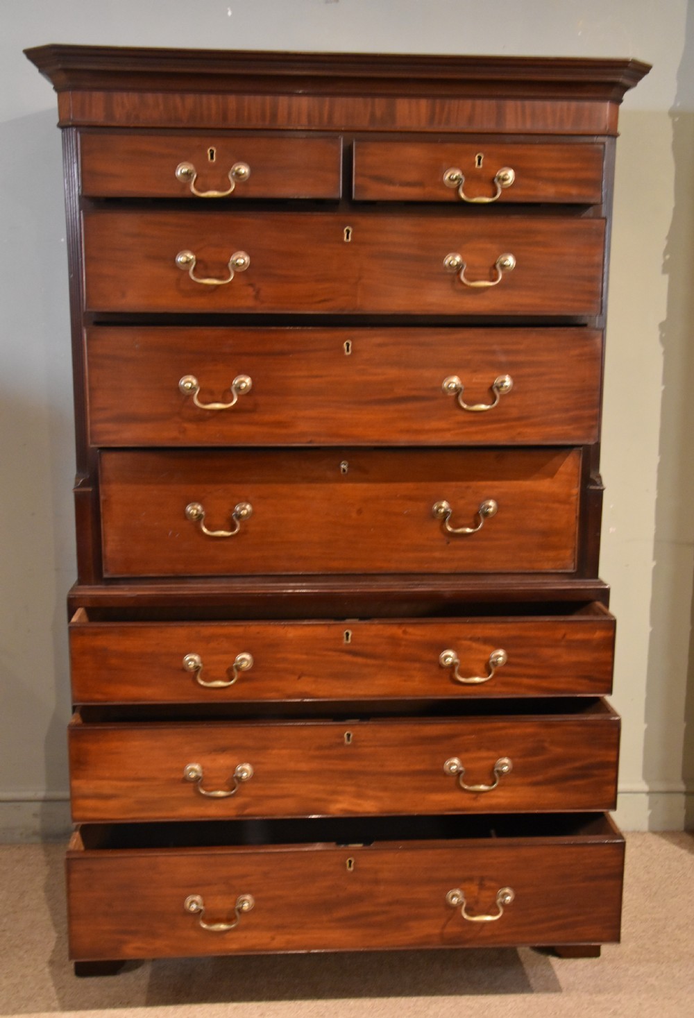 A George III mahogany chest on chest with an open secretaire drawer displaying small internal drawers, pigeonholes, and a green writing surface. View IX