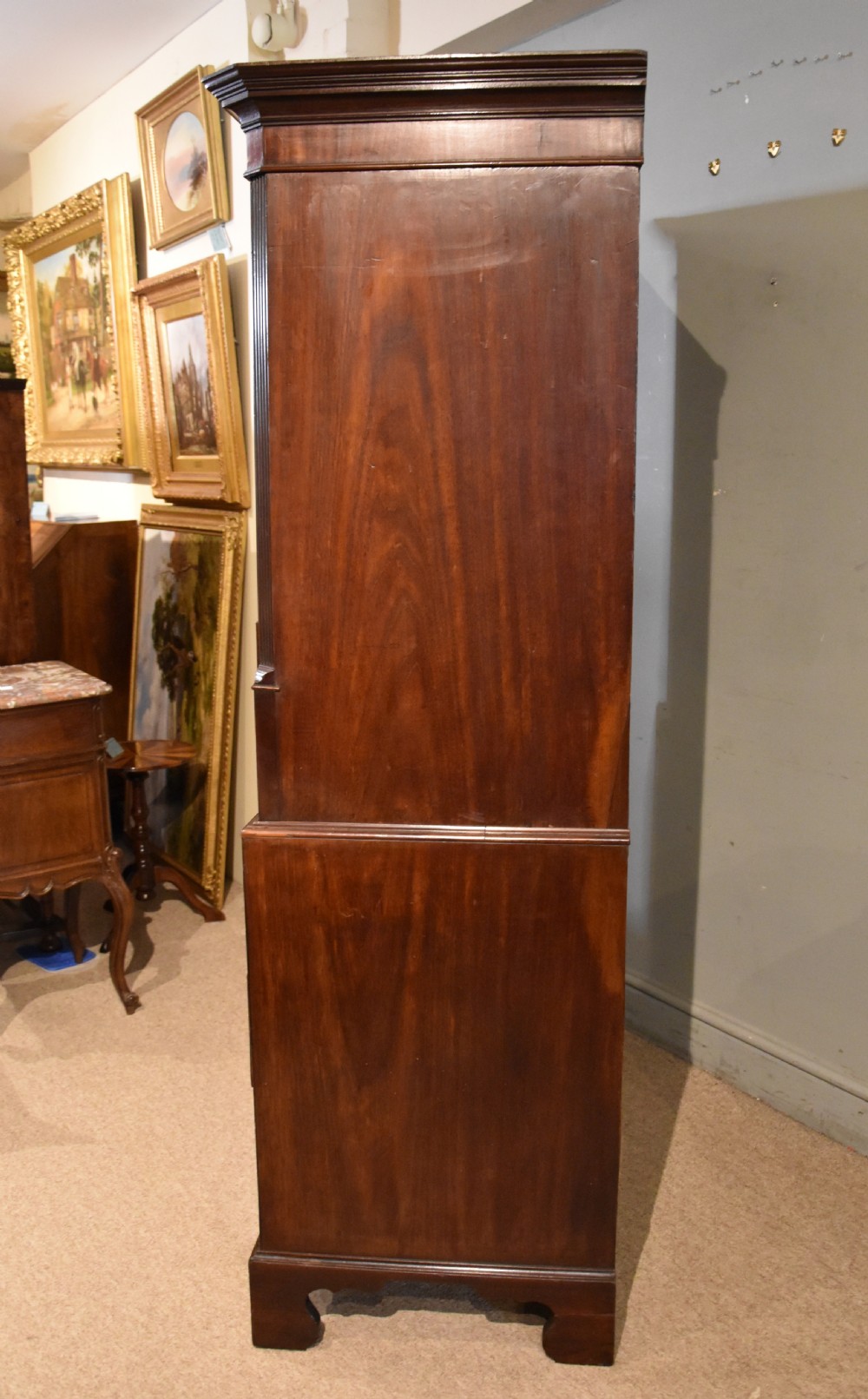 A George III mahogany chest on chest with an open secretaire drawer displaying small internal drawers, pigeonholes, and a green writing surface. View XI