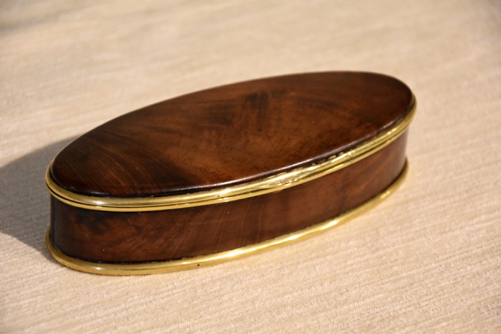 An eighteenth-century oval walnut table snuff box with figured grain and polished brass rim bindings. View II