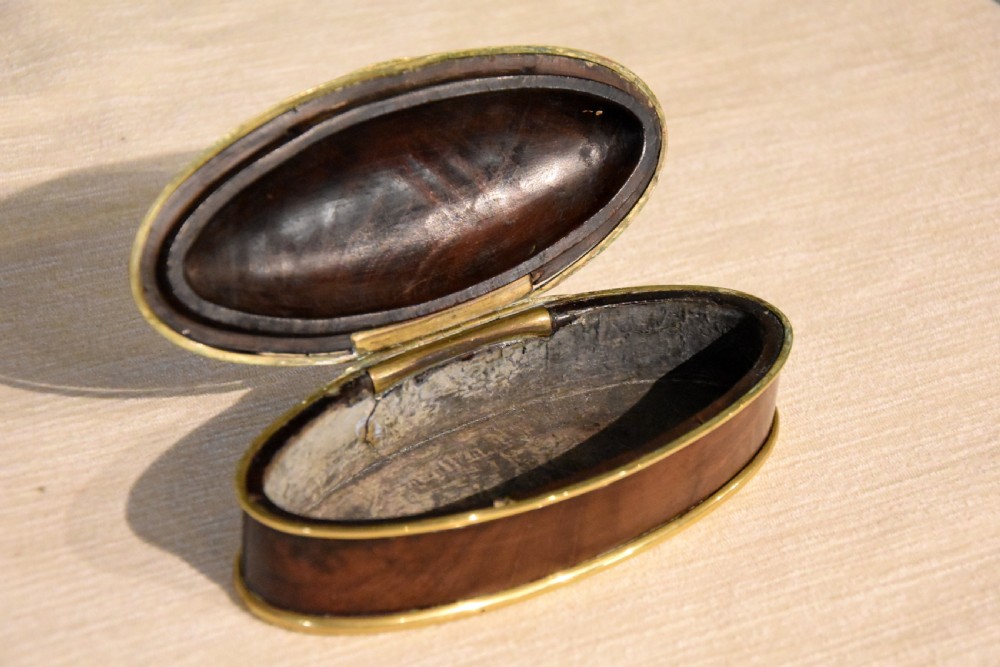 An eighteenth-century oval walnut table snuff box with figured grain and polished brass rim bindings. View III