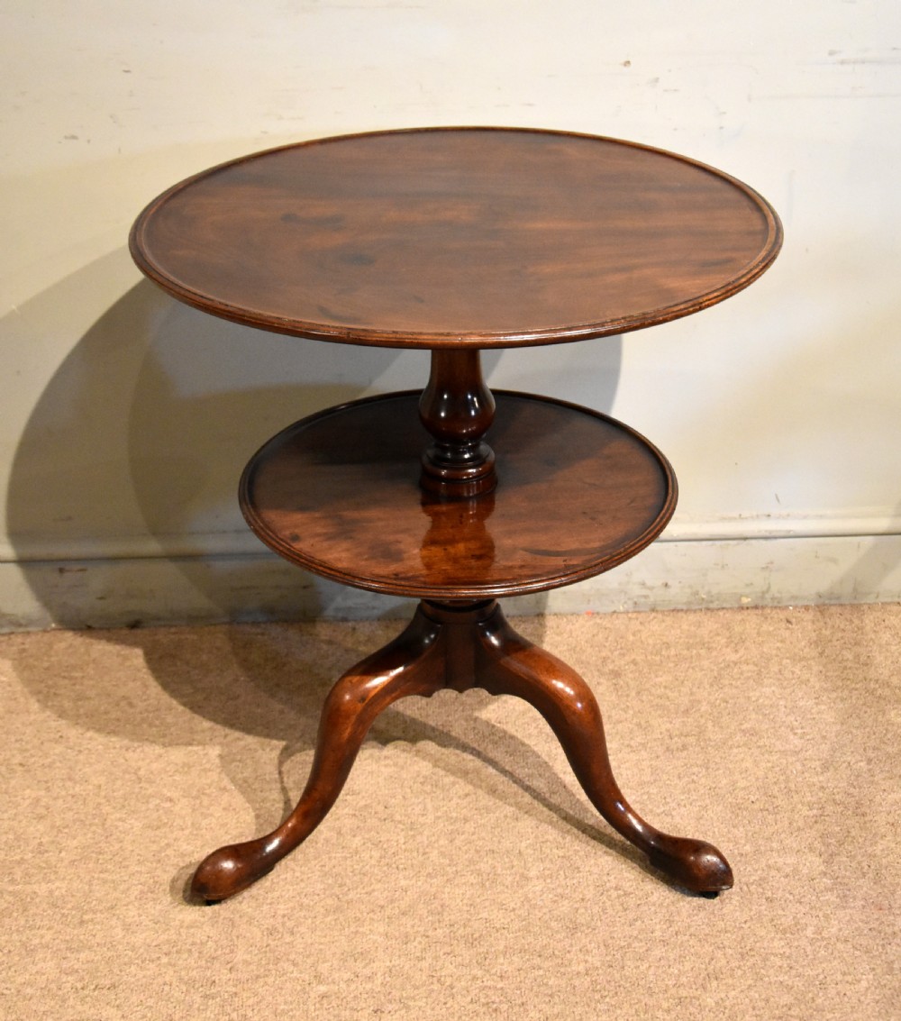 A George III mahogany two-tier tripod table featuring two circular trays supported by a central turned baluster stem and three cabriole legs ending in pad feet. View III