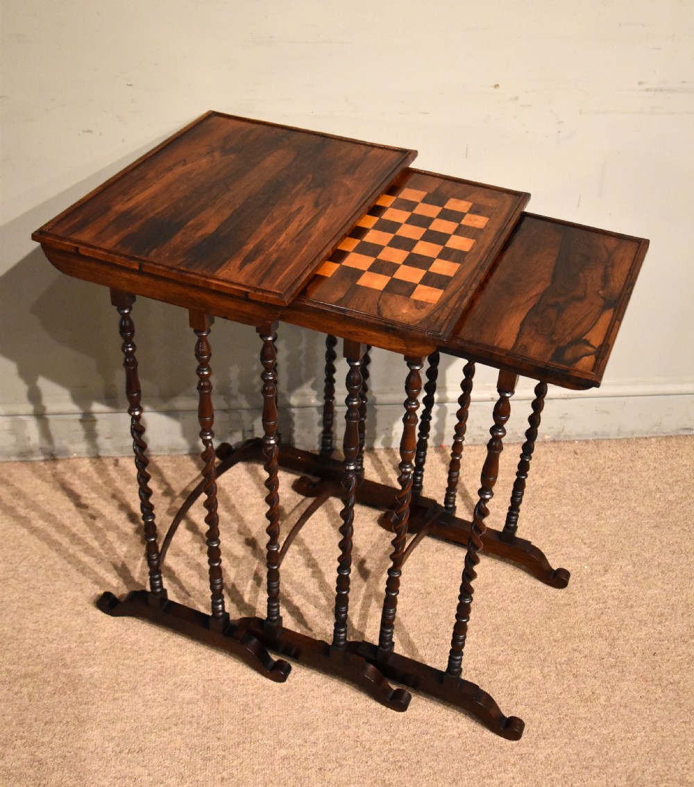 A set of three nested Regency rosewood occasional tables featuring barley twist legs, curved stretchers, and an inlaid chessboard top on the middle table. View II