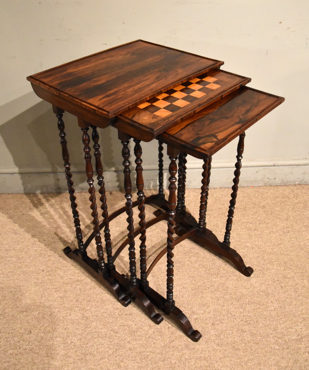 A set of three nested Regency rosewood occasional tables featuring barley twist legs, curved stretchers, and an inlaid chessboard top on the middle table. View VI