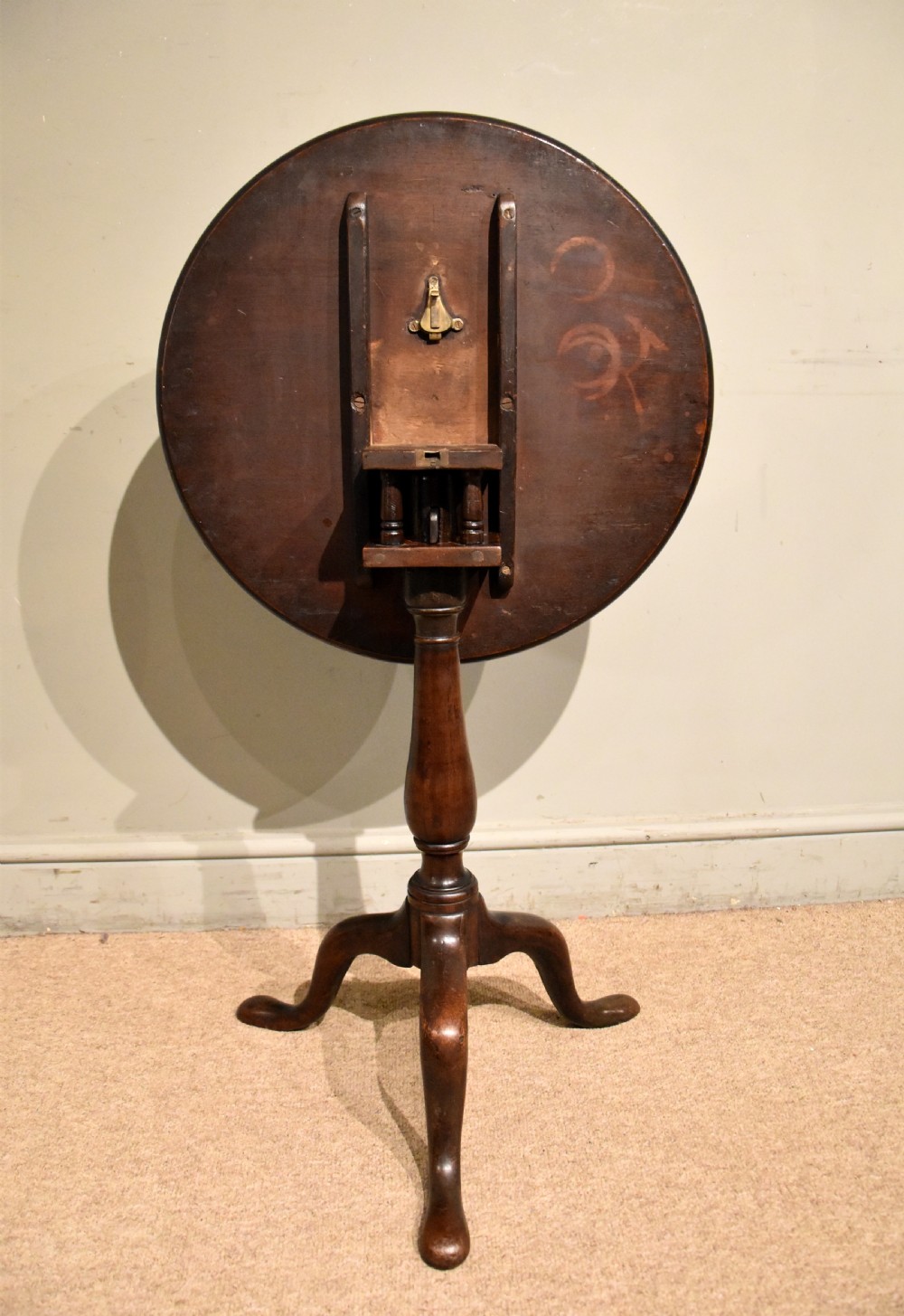 A George III mahogany wine table featuring a circular tilt top surface mounted on a turned pedestal stem and tripod legs. View II