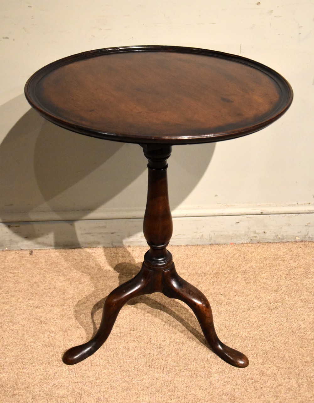 A George III mahogany wine table featuring a circular tilt top surface mounted on a turned pedestal stem and tripod legs. View IV