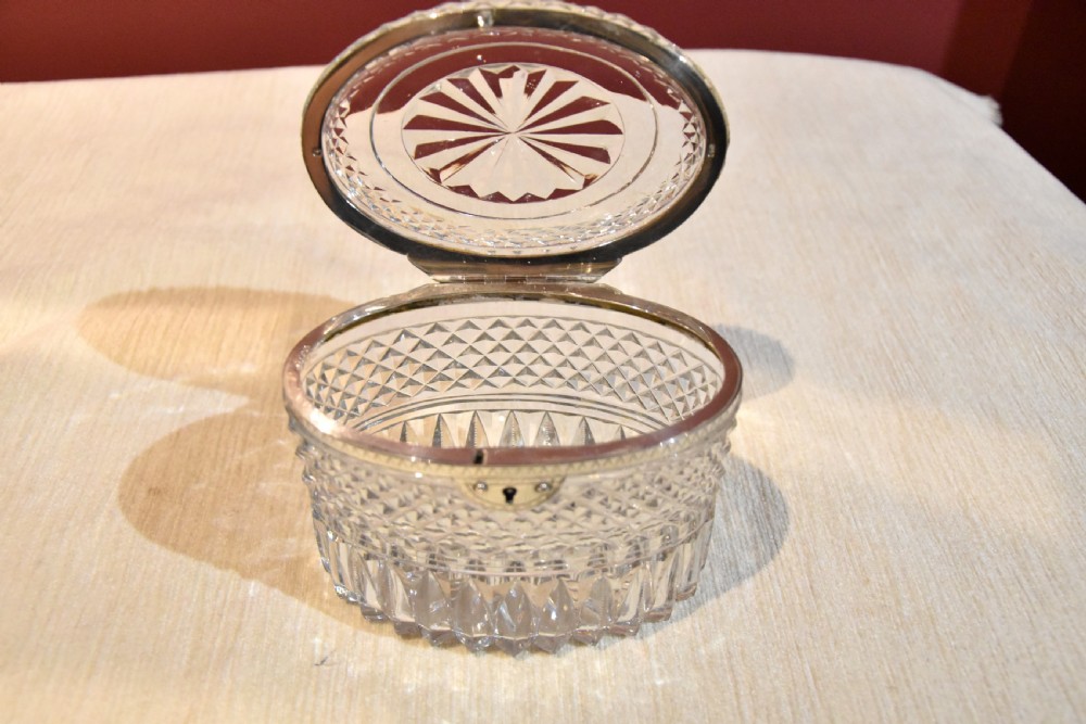 An oval cut glass Georgian tea caddy featuring diamond faceting, a hinged lid, and a silver lock plate with keyhole. View IV