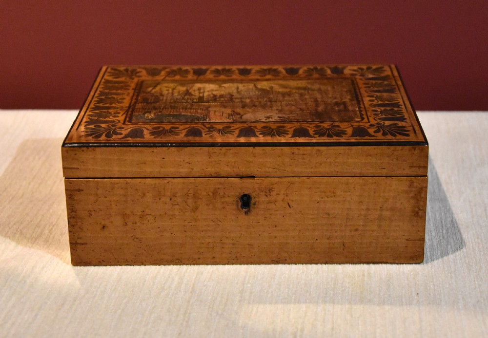 A rectangular 19th-century sycamore wood box featuring a printed architectural scene on the lid surrounded by a stylized leaf border and a keyhole on the front. View III