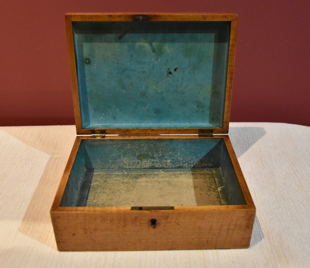 A rectangular 19th-century sycamore wood box featuring a printed architectural scene on the lid surrounded by a stylized leaf border and a keyhole on the front. View V