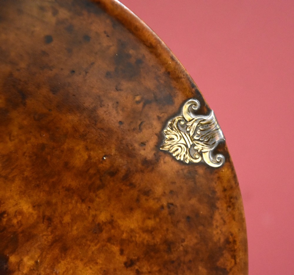 A circular shallow bowl carved from figured brown burr wood, featuring six chased silver mounts positioned around the rim. View III