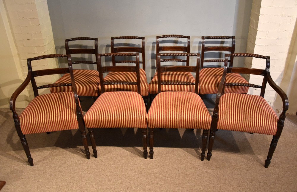 A set of eight Regency mahogany dining chairs featuring carved rope-twist top rails and striped upholstered seats.