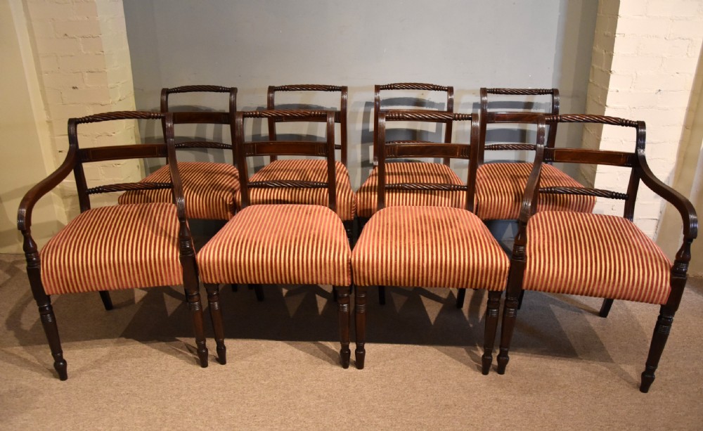 A set of eight Regency mahogany dining chairs featuring carved rope-twist top rails and striped upholstered seats. View II