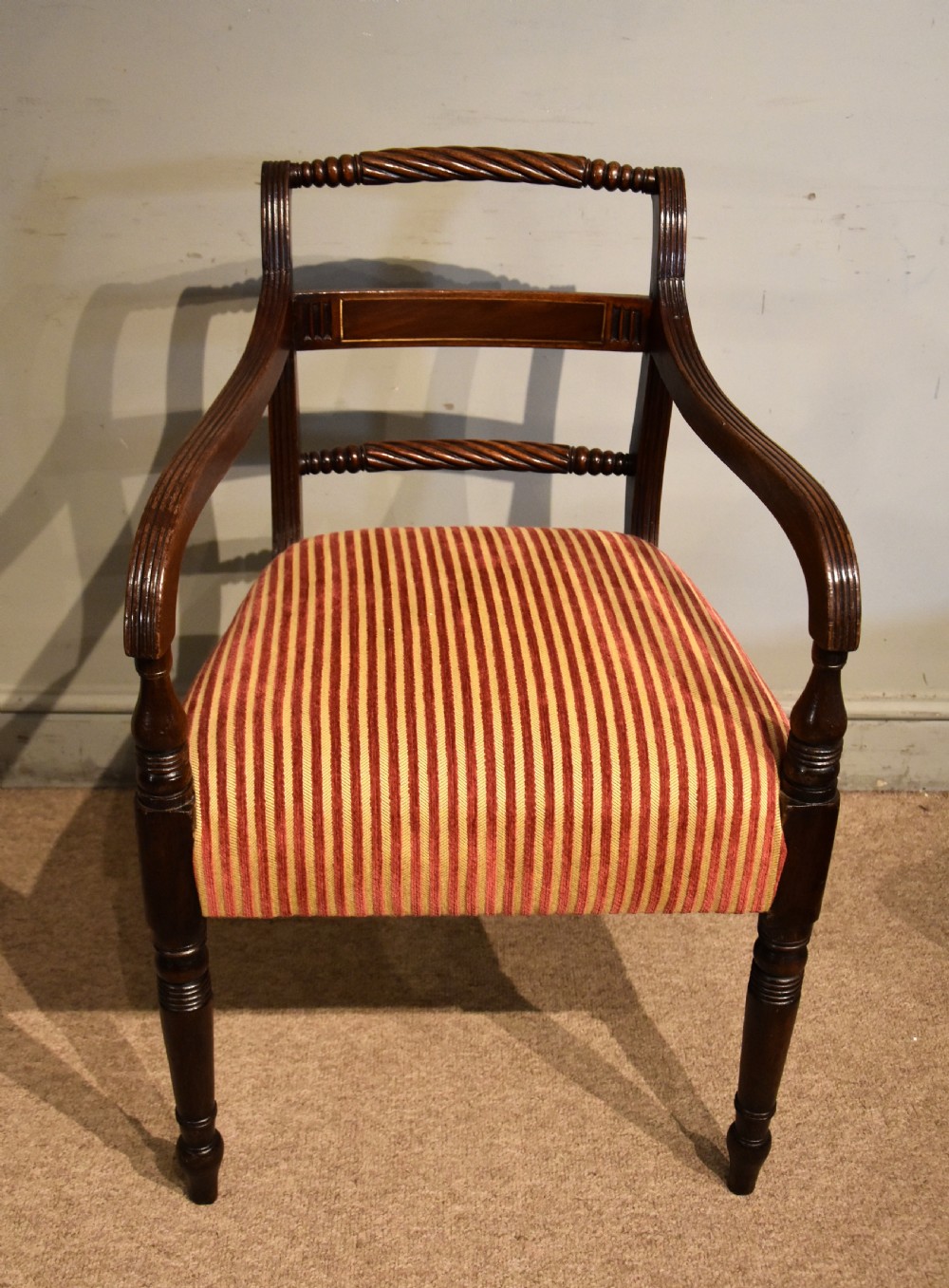A set of eight Regency mahogany dining chairs featuring carved rope-twist top rails and striped upholstered seats. View VIII