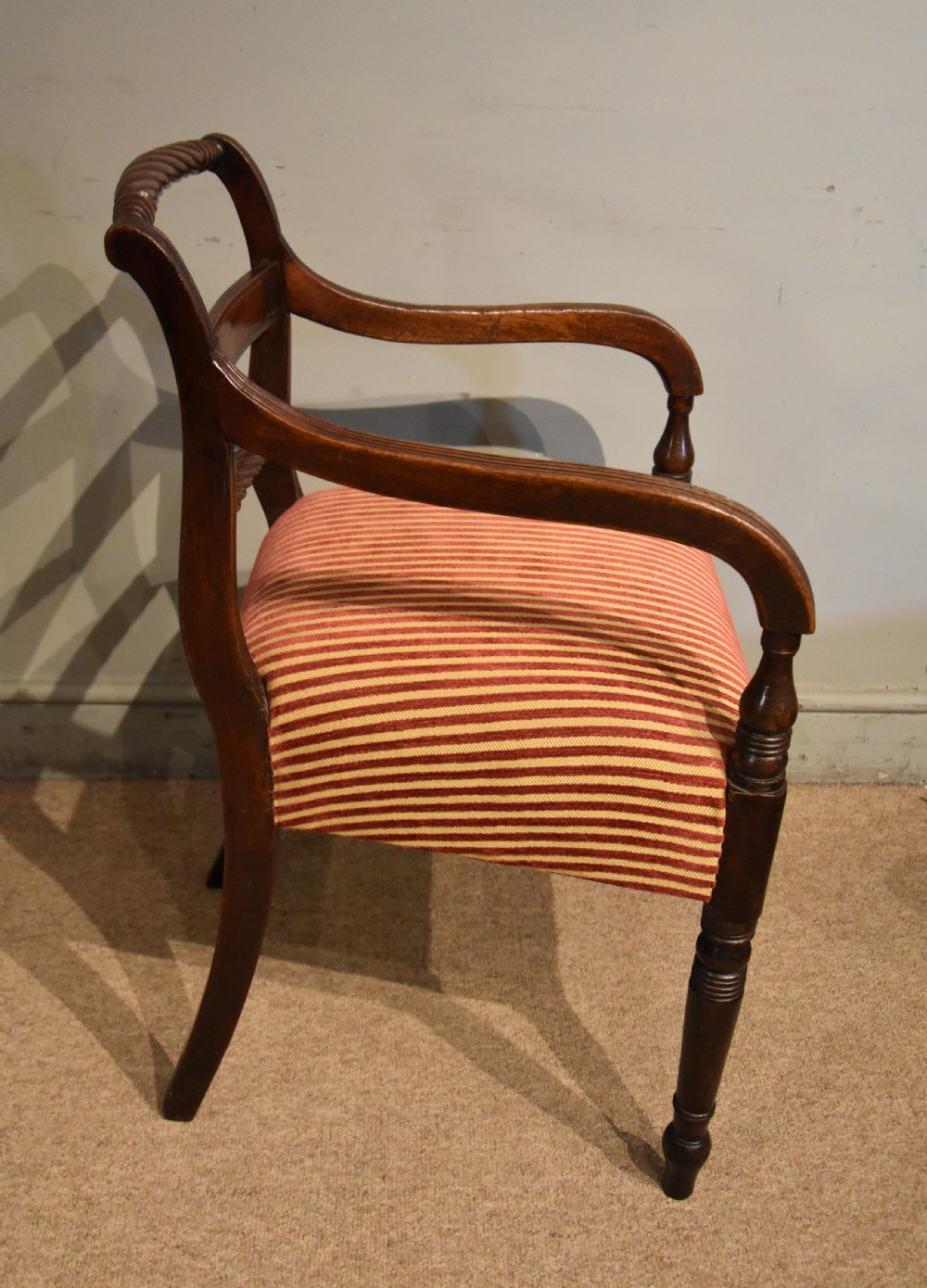 A set of eight Regency mahogany dining chairs featuring carved rope-twist top rails and striped upholstered seats. View IX