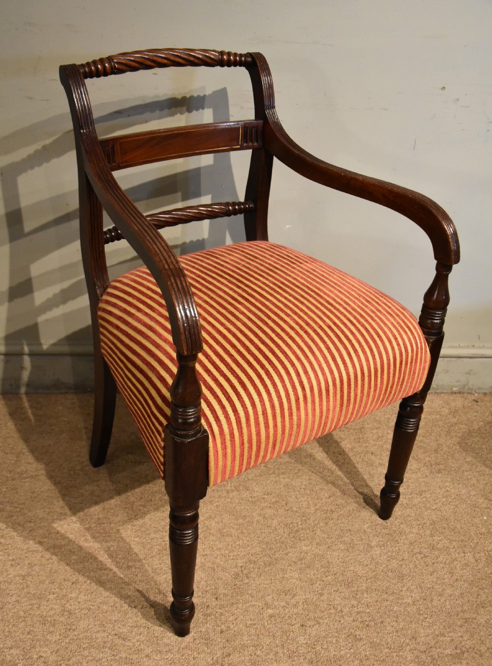 A set of eight Regency mahogany dining chairs featuring carved rope-twist top rails and striped upholstered seats. View X