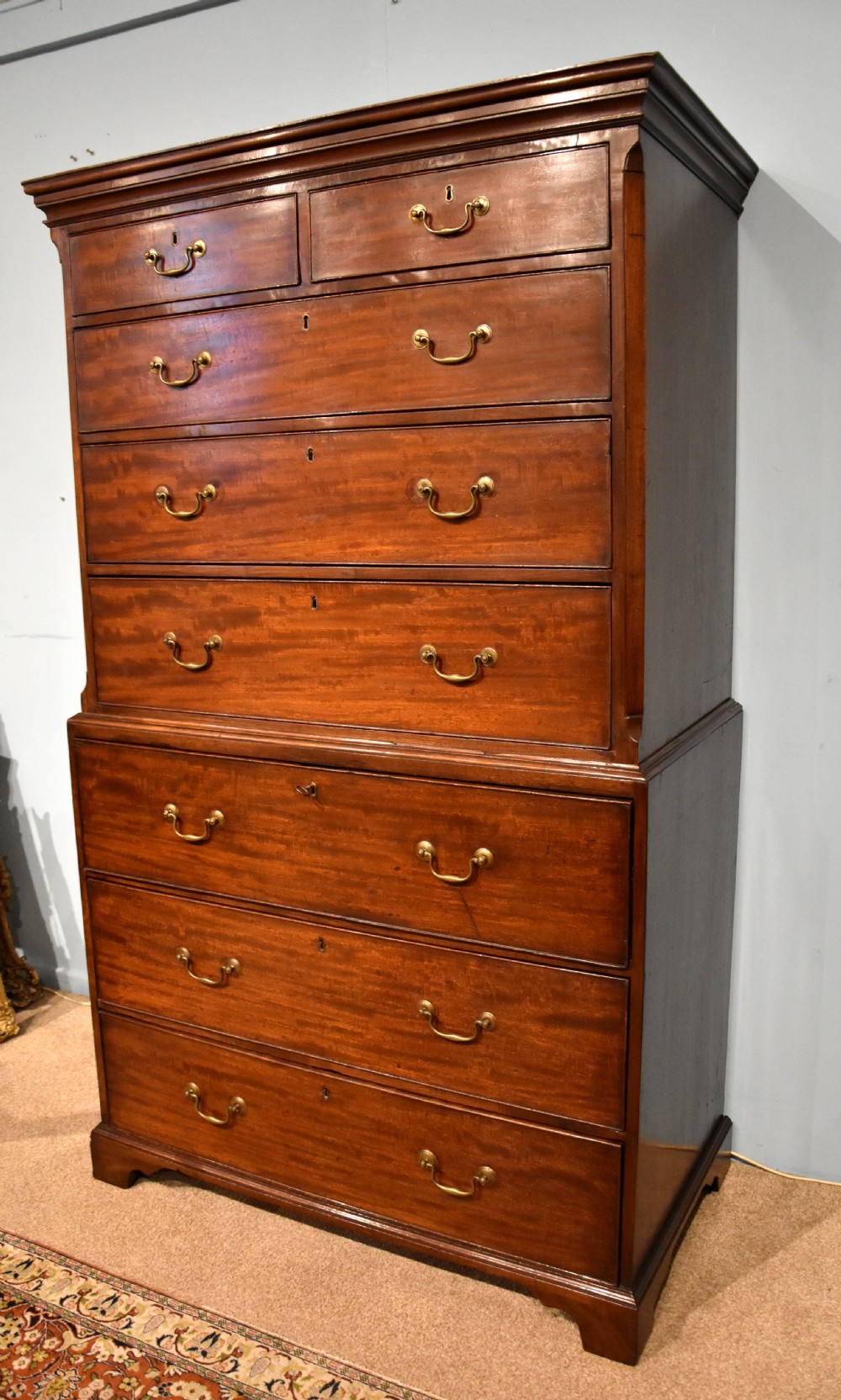 An eighteenth-century mahogany chest on chest featuring two short over six long graduated drawers with brass swan-neck handles and bracket feet. View II