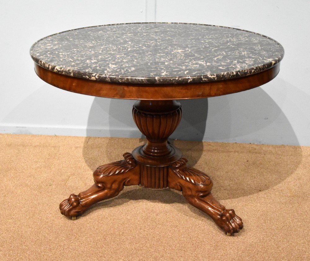 A 19th-century French mahogany gueridon table featuring a circular dark marble top supported by a reeded pedestal stem and carved triform base with paw feet. View IV