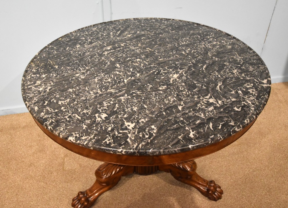 A 19th-century French mahogany gueridon table featuring a circular dark marble top supported by a reeded pedestal stem and carved triform base with paw feet. View VII