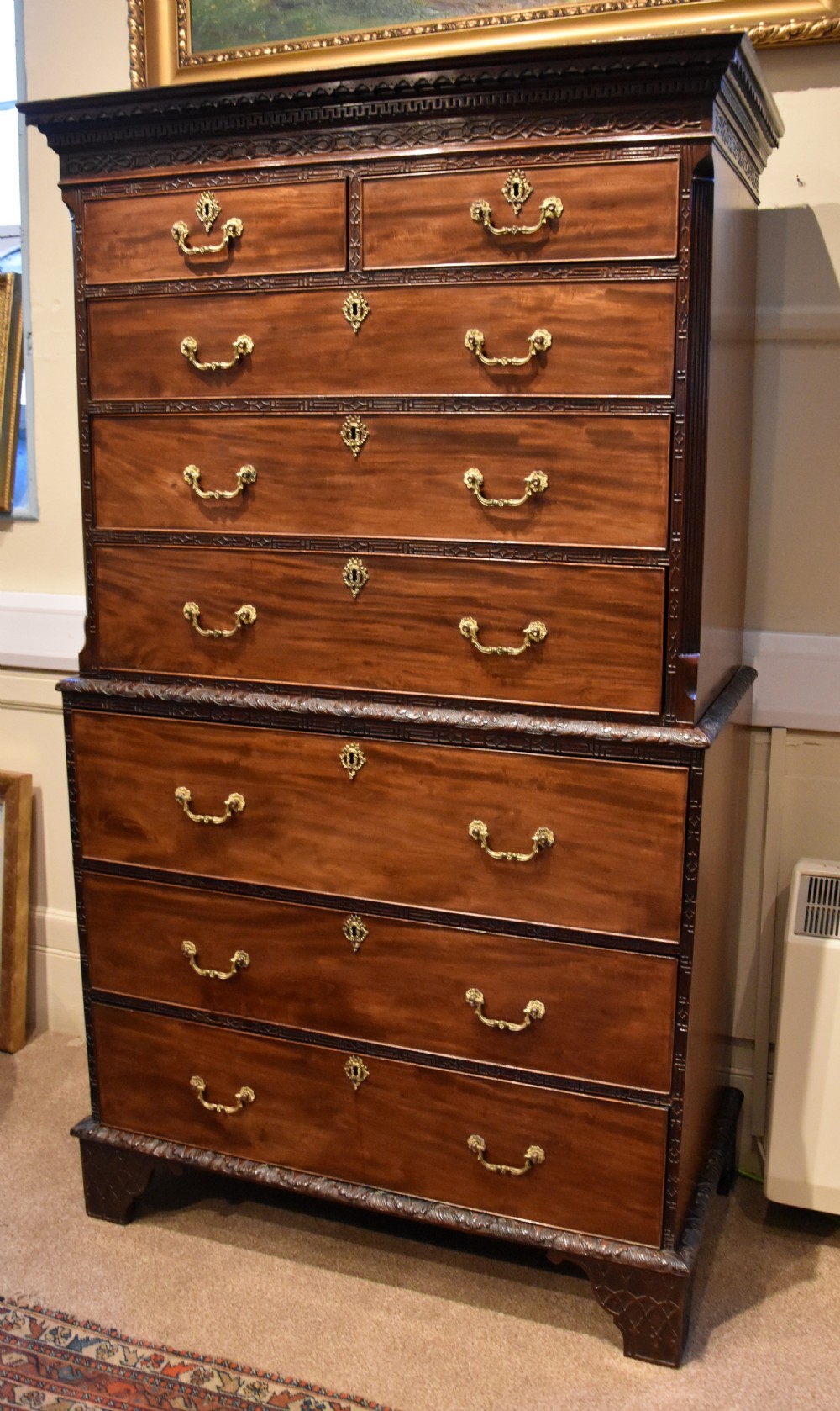An eighteenth-century carved mahogany chest on chest featuring geometric fretwork mouldings, brass swan-neck handles, and carved bracket feet. View II