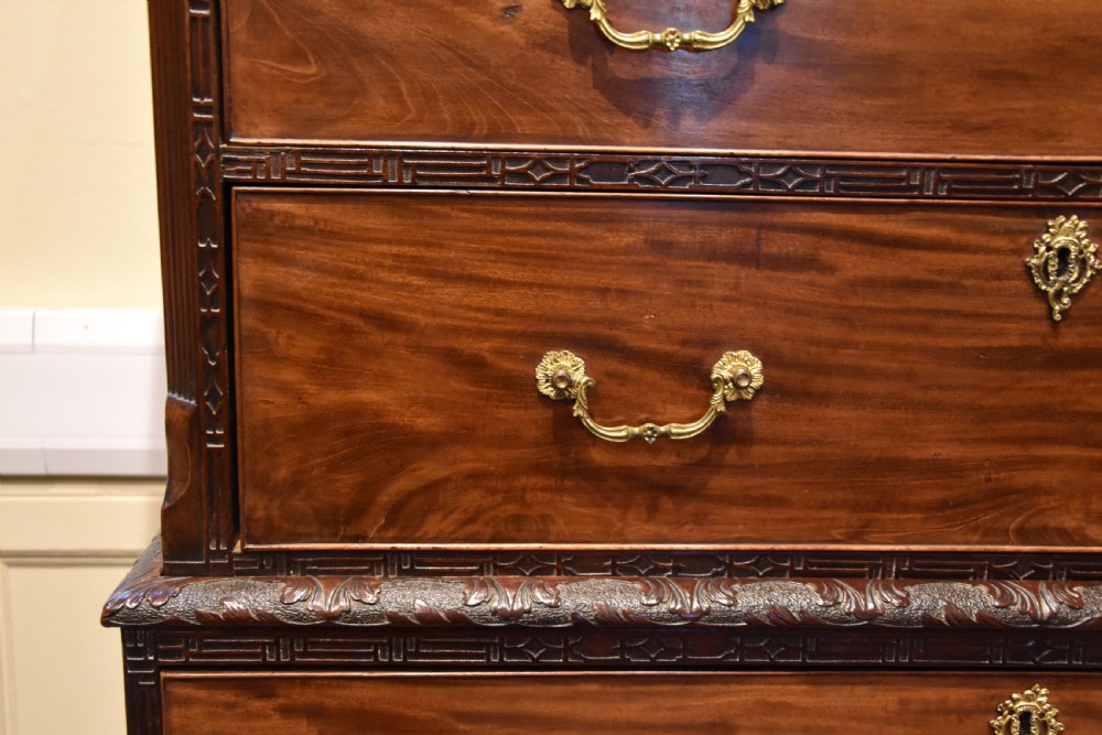 An eighteenth-century carved mahogany chest on chest featuring geometric fretwork mouldings, brass swan-neck handles, and carved bracket feet. View V
