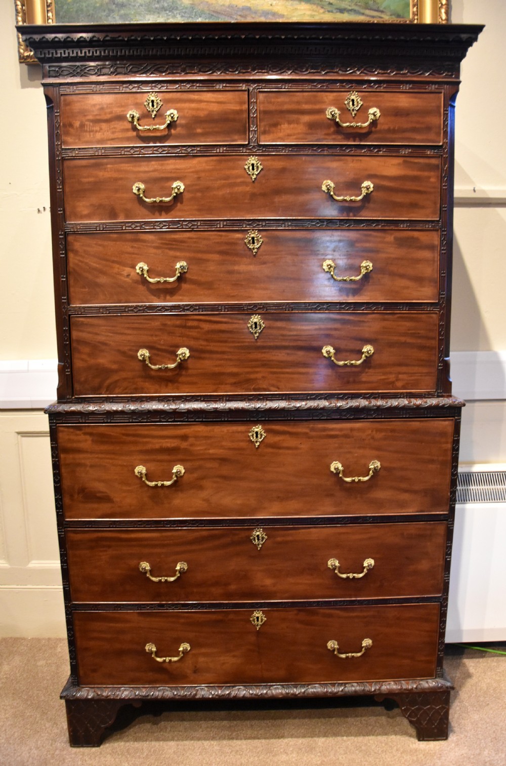 An eighteenth-century carved mahogany chest on chest featuring geometric fretwork mouldings, brass swan-neck handles, and carved bracket feet. View VII