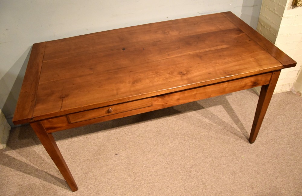 A mid 19th-century French farmhouse table in warm brown fruitwood featuring a single frieze drawer and tapered square legs. View IV