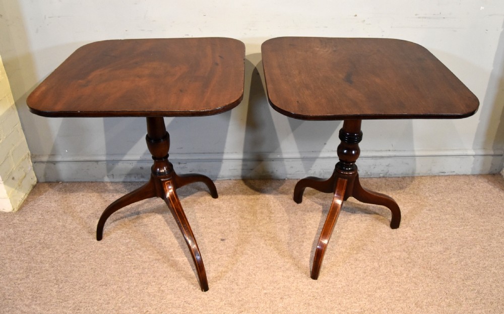 A matched pair of mahogany tripod tables featuring turned pedestals and square tops with rounded corners. View II