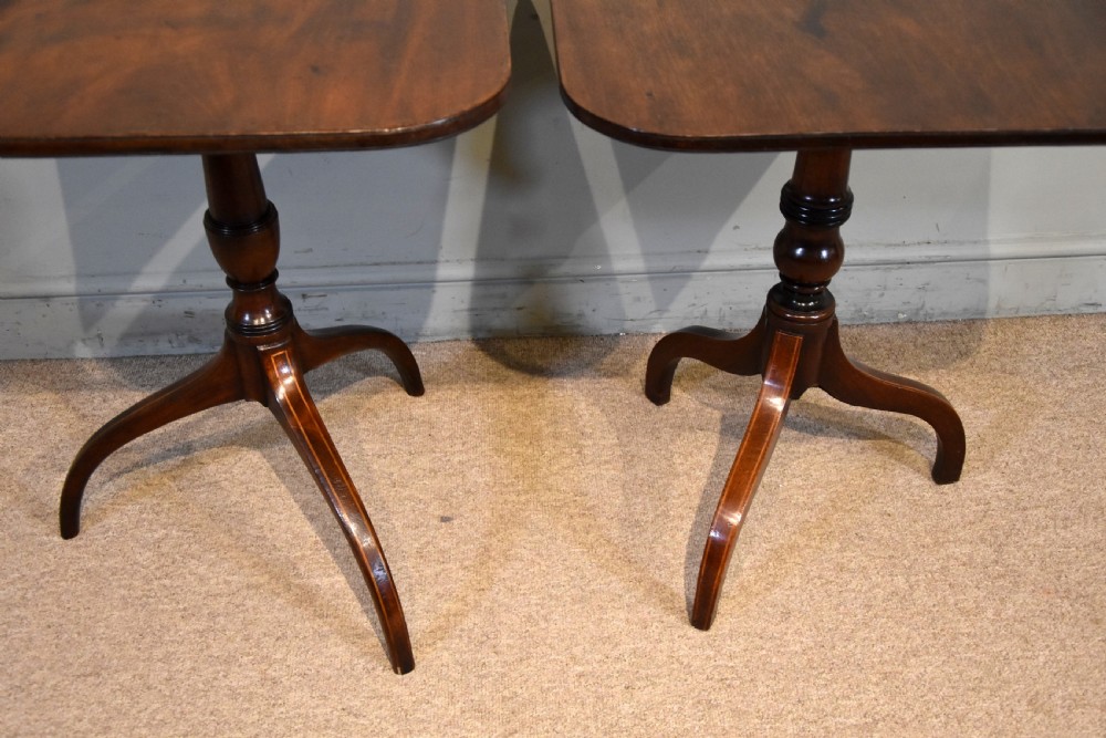 A matched pair of mahogany tripod tables featuring turned pedestals and square tops with rounded corners. View III