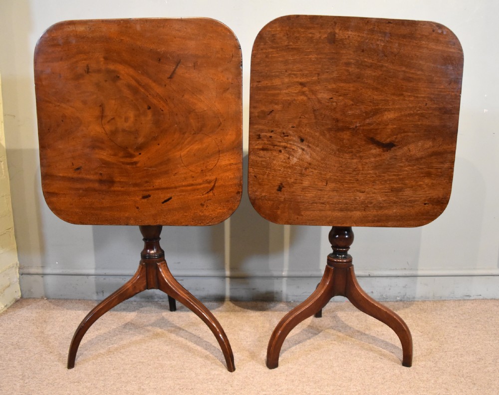 A matched pair of mahogany tripod tables featuring turned pedestals and square tops with rounded corners. View IV