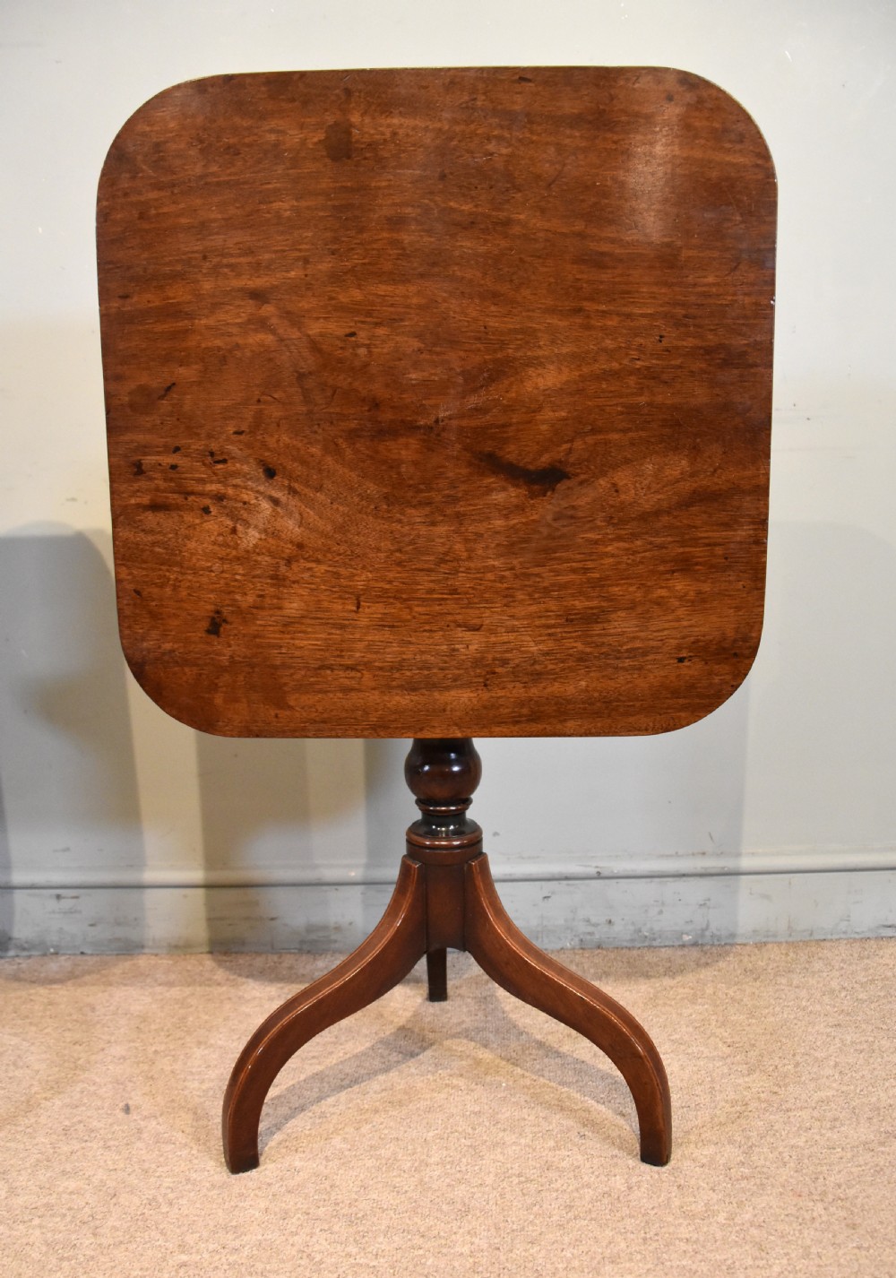 A matched pair of mahogany tripod tables featuring turned pedestals and square tops with rounded corners. View V