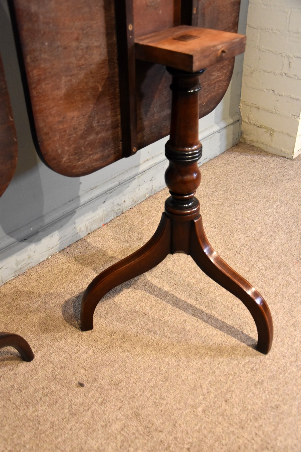 A matched pair of mahogany tripod tables featuring turned pedestals and square tops with rounded corners. View VIII