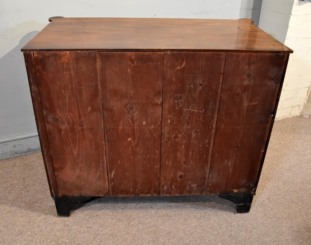 A Regency period mahogany chest of drawers featuring flame mahogany drawer fronts, turned brass knobs, and reeded side columns. View IX