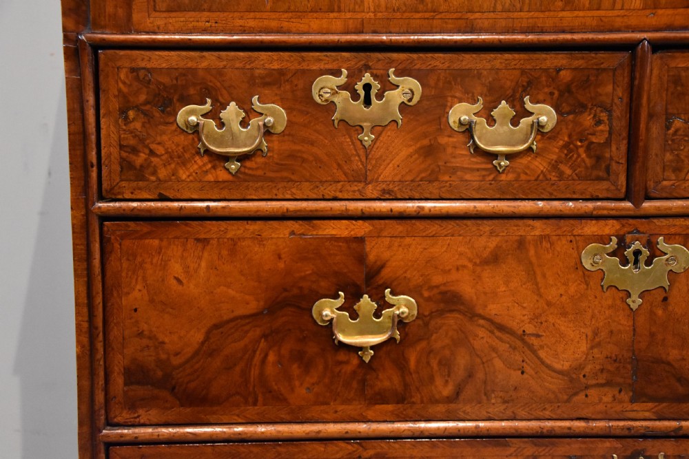 A George II walnut veneered bureau featuring a slant-front writing lid above four drawers with decorative brass handles and bracket feet. View IX