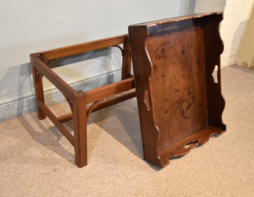 A mid-eighteenth-century mahogany butlers tray featuring scalloped gallery sides with cut-out handles, resting on a fitted rectangular wooden stand with corner spandrels. View VI