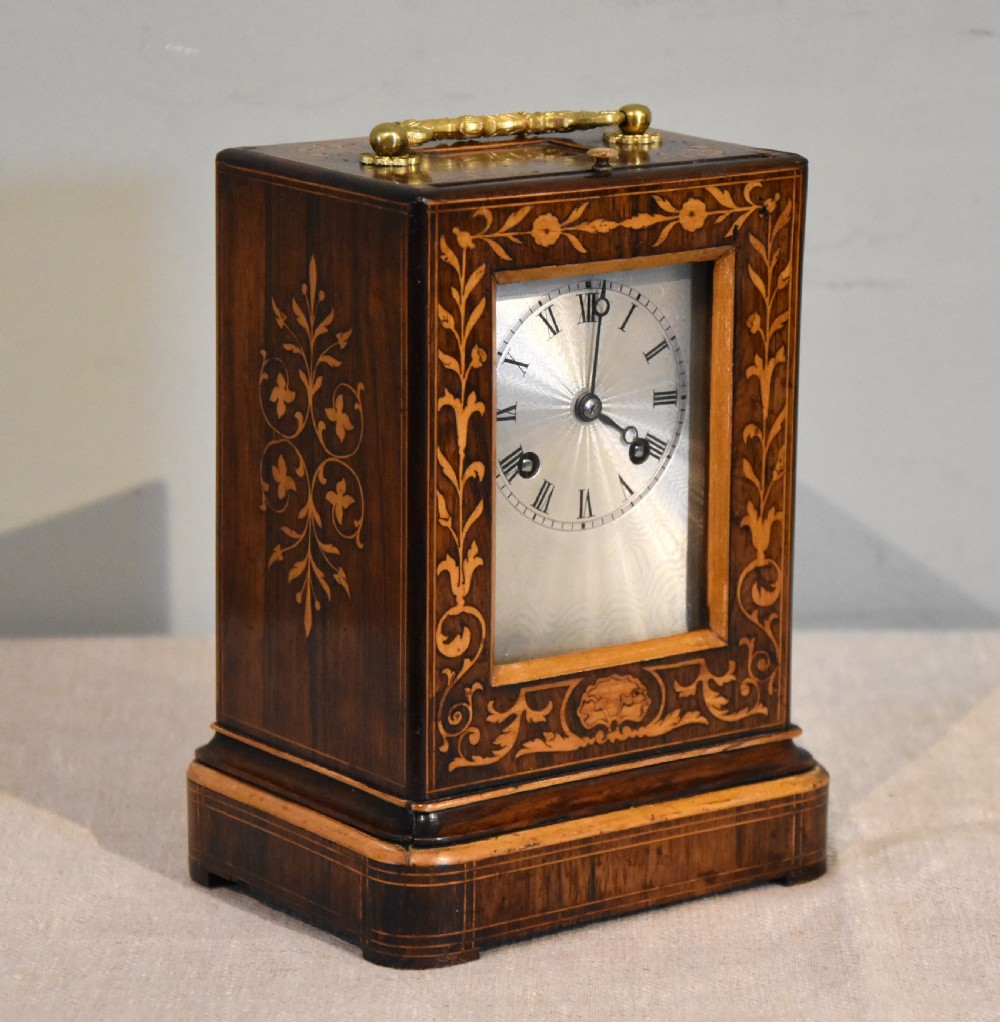 An antique French rectangular rosewood mantel clock featuring foliate marquetry inlay, a silvered engine-turned dial with Roman numerals, and a gilt brass handle. View II
