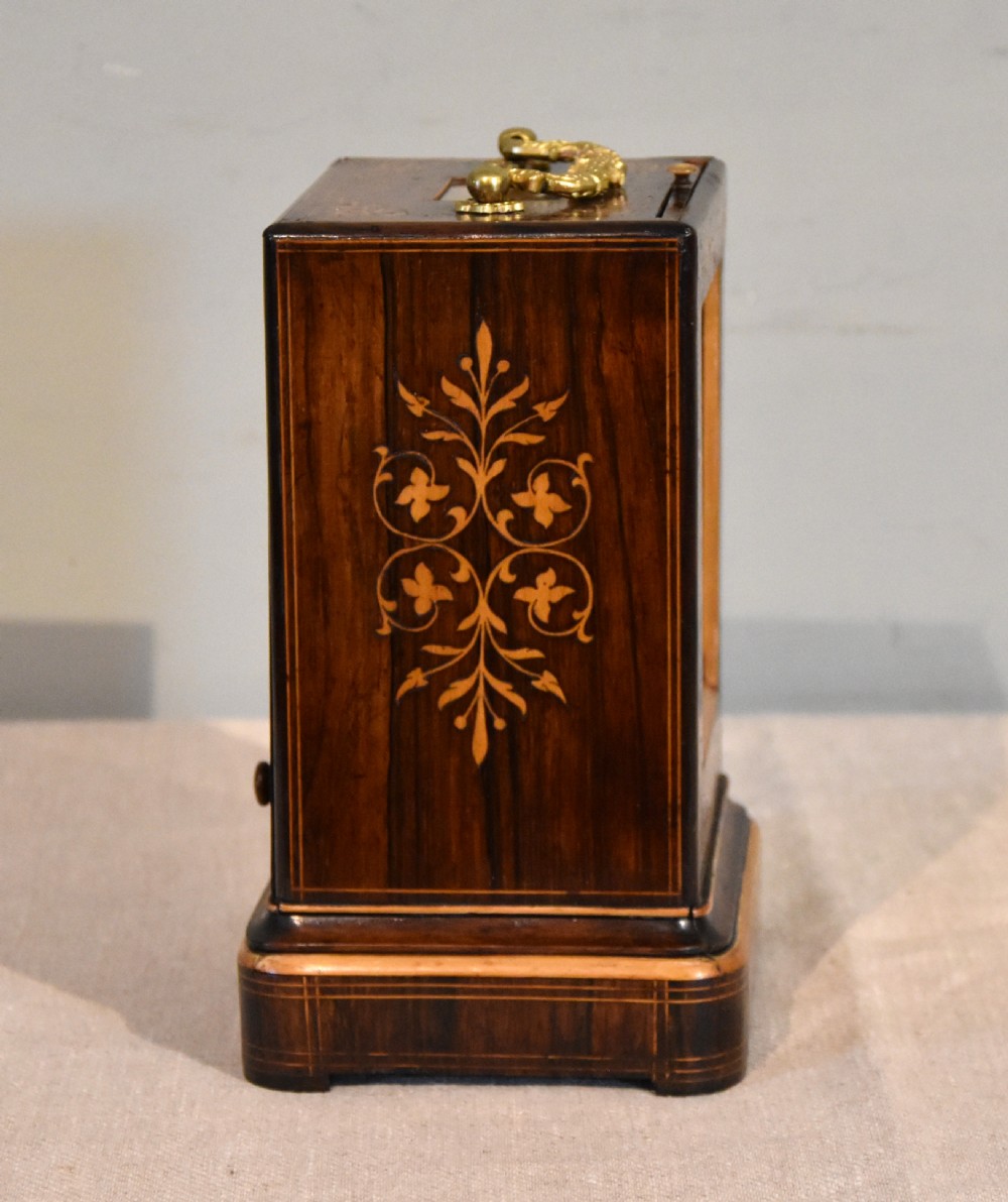 An antique French rectangular rosewood mantel clock featuring foliate marquetry inlay, a silvered engine-turned dial with Roman numerals, and a gilt brass handle. View V