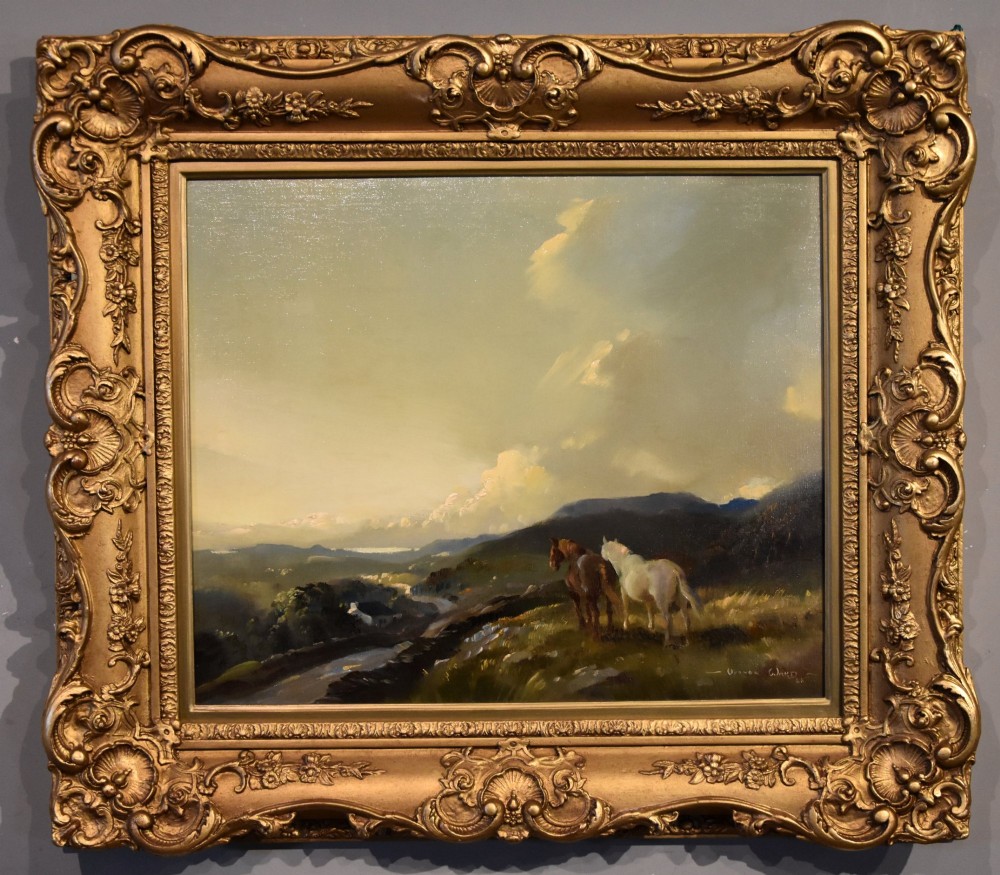 An oil painting depicting two horses on a grassy hill under a cloudy sky, displayed in an ornate carved giltwood frame.