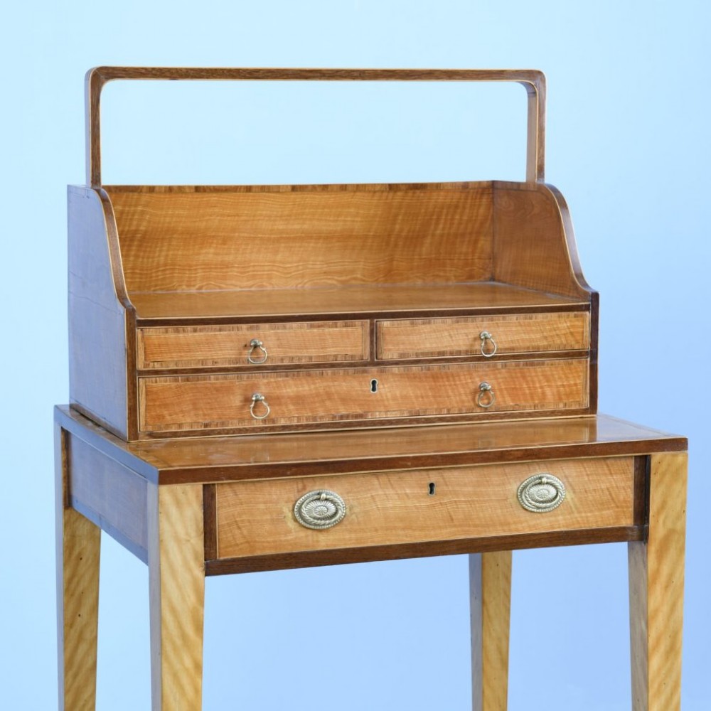 An 18th-century Georgian satinwood cheveret writing table featuring slender tapered legs, a lower drawer, and an upper removable book trough with handle. View VI