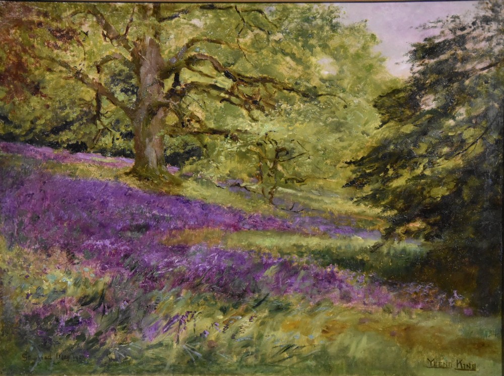 An antique oil painting depicting a woodland landscape with purple flowers beneath a tree, displayed within an ornate gilt frame. View II