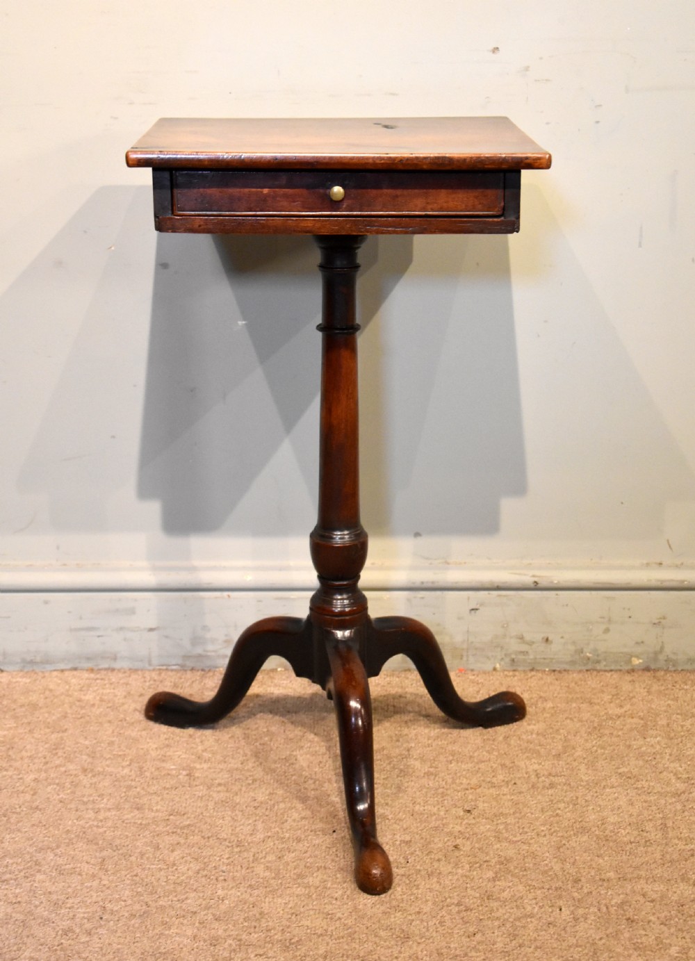 Mid-18th-century mahogany wine table featuring a rectangular top with a small drawer, supported by a turned central stem and three cabriole legs. View II