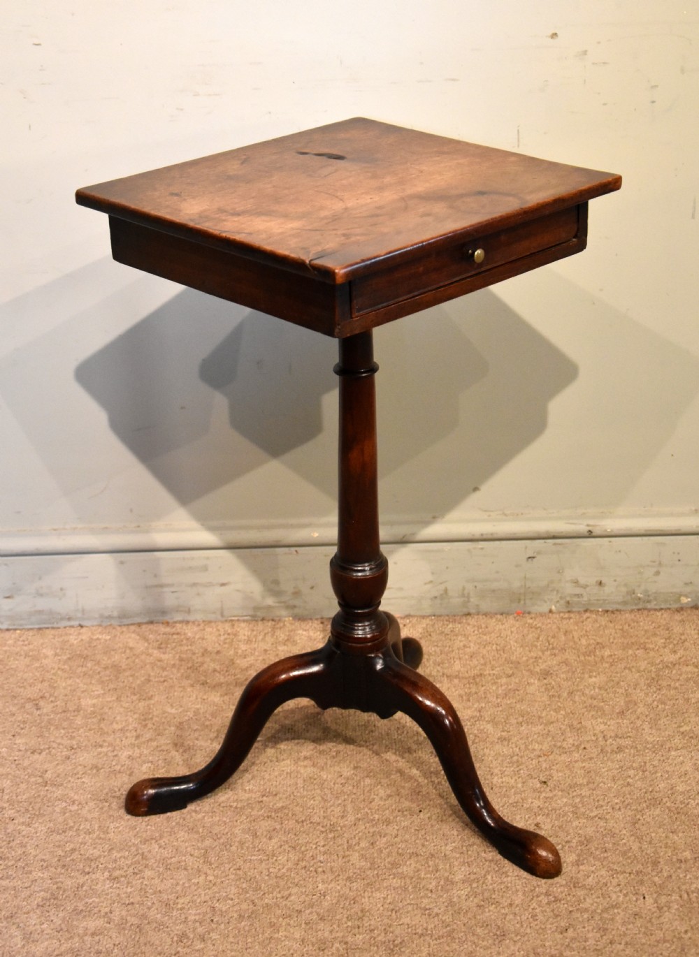 Mid-18th-century mahogany wine table featuring a rectangular top with a small drawer, supported by a turned central stem and three cabriole legs. View V