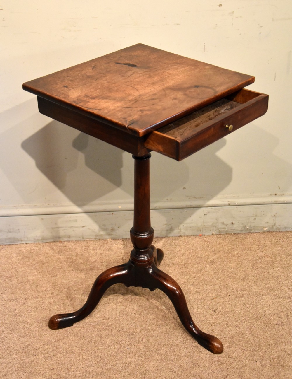 Mid-18th-century mahogany wine table featuring a rectangular top with a small drawer, supported by a turned central stem and three cabriole legs. View VI